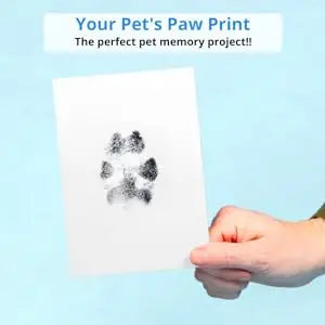 image of hand holding a black paw print on white paper image text: "your pets paw print the perfect pet memory project"